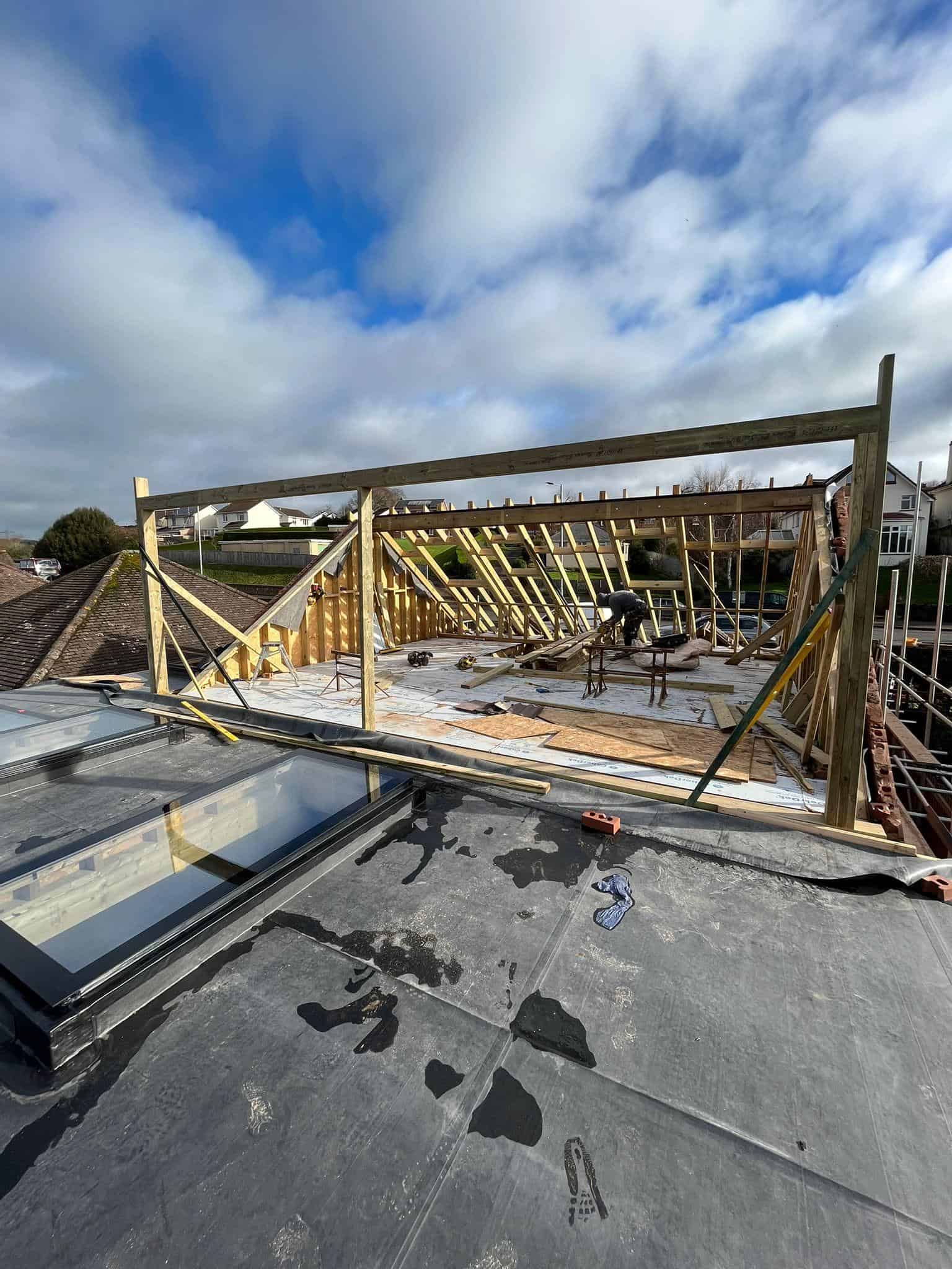 New roof construction by JB Carpentry & Construction in progress, featuring timber framing and roofing work.