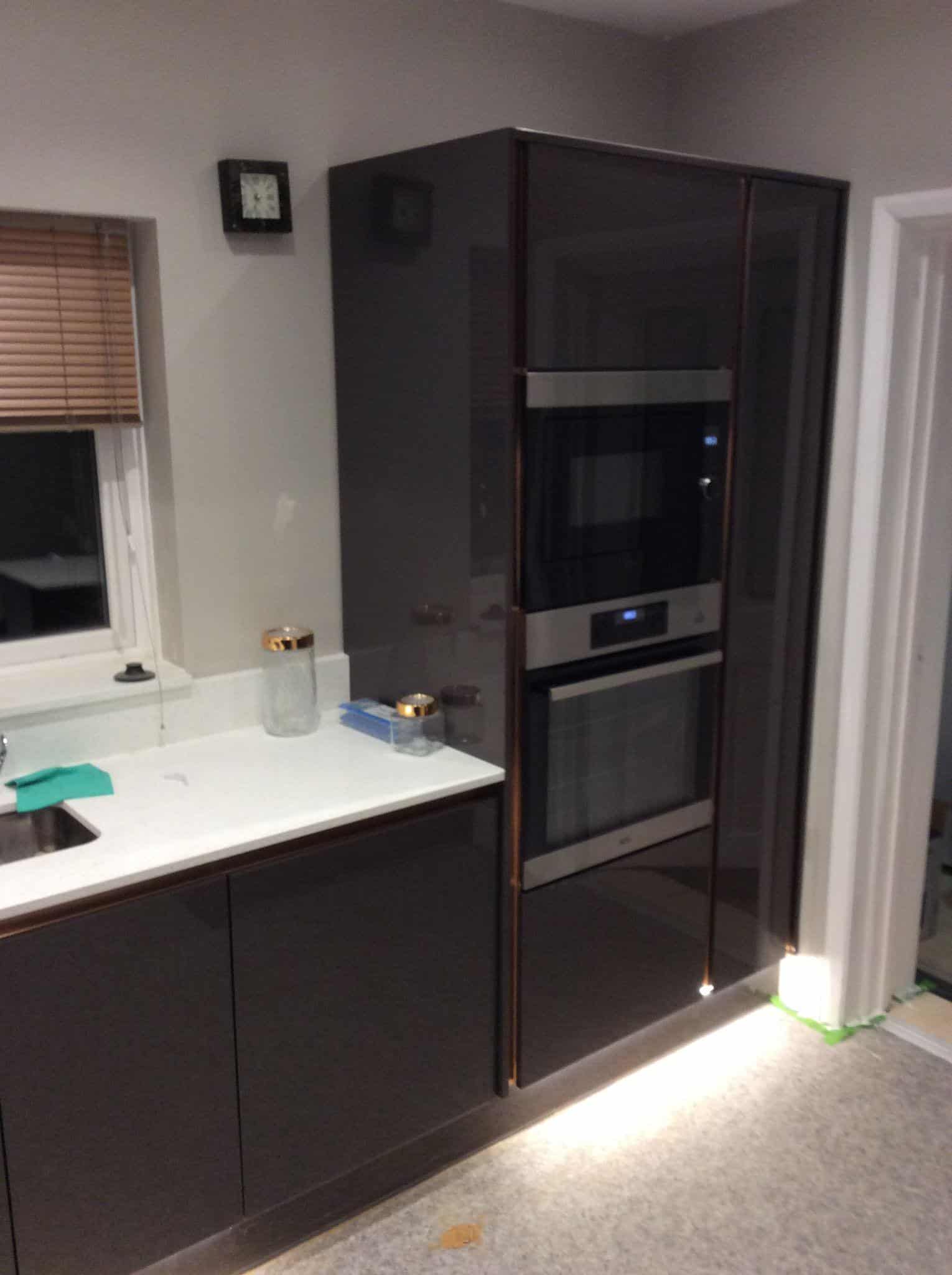 Sleek black kitchen cabinetry with integrated oven, custom-built by JB Carpentry & Construction.