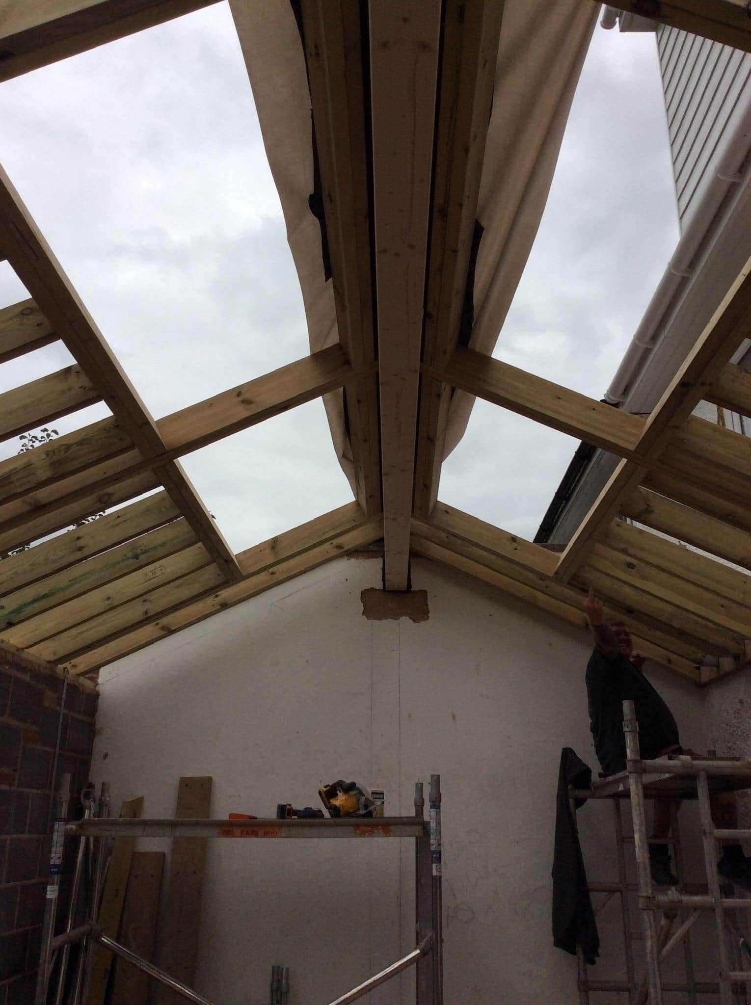 Roof carpentry and construction work under progress with wooden framing in a residential project.