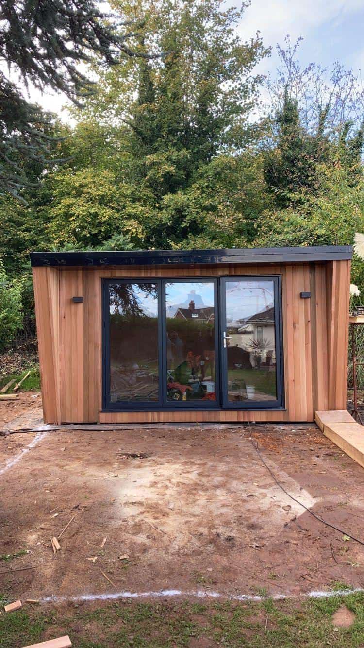Modern timber garden office with large glass doors, custom carpentry, and construction by JB Carpentry & Construction.
