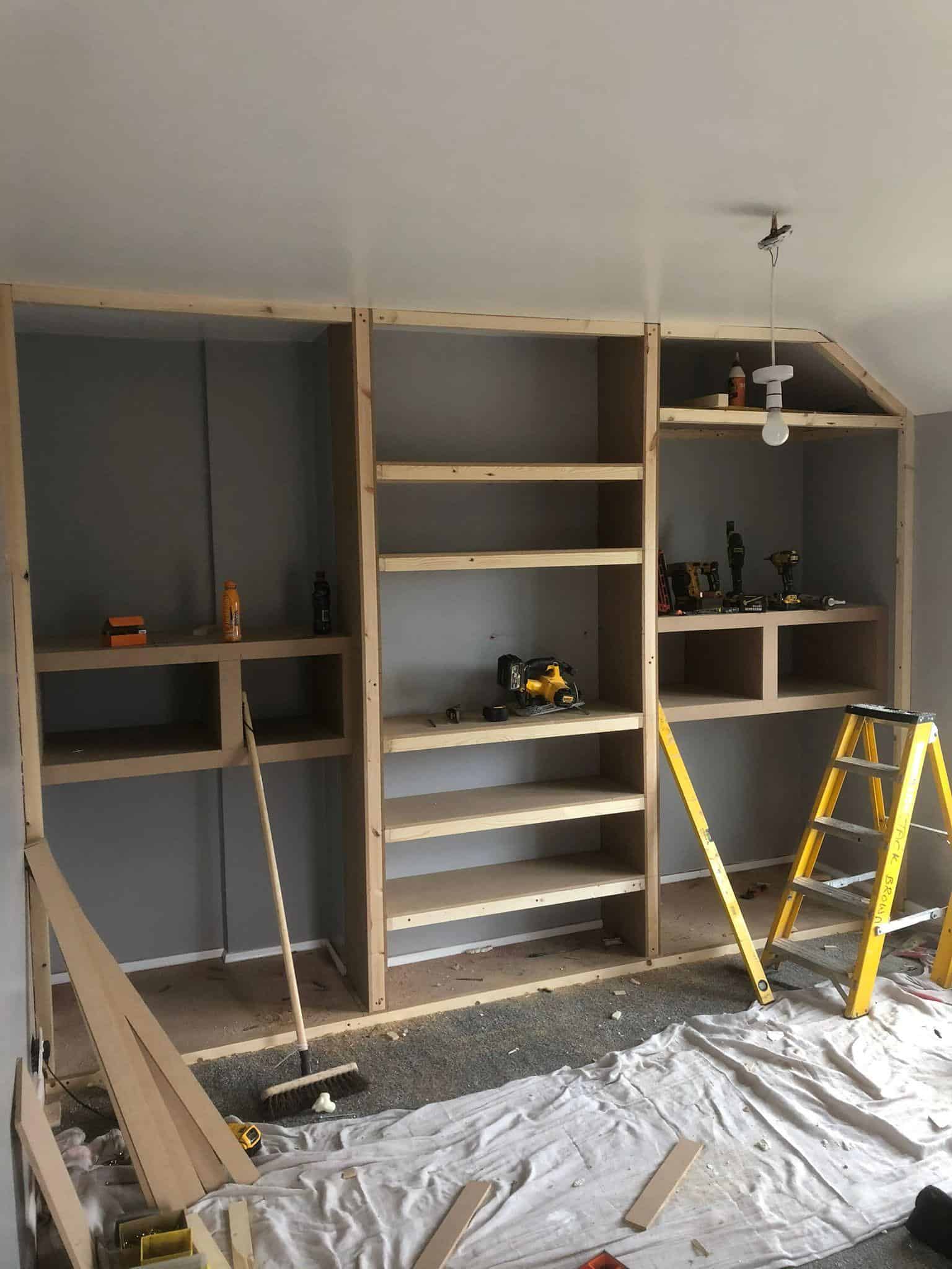 Light wooden built-in shelving unit in progress for home storage, part of JB Carpentry & Construction.