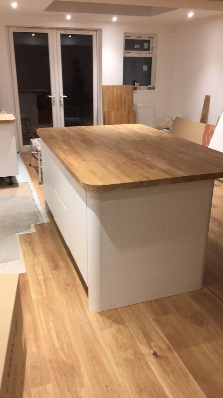 Modern kitchen island with wooden countertop and white base, custom carpentry work by JB Carpentry & Construction.