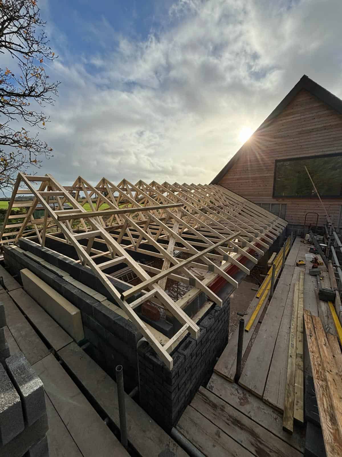 Wooden roof truss construction for a new building by JB Carpentry & Construction, expert in roofing and carpentry.
