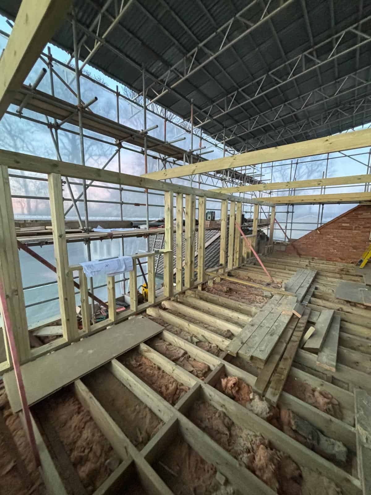 Steel and wooden framework under construction at a building site by JB Carpentry & Construction.