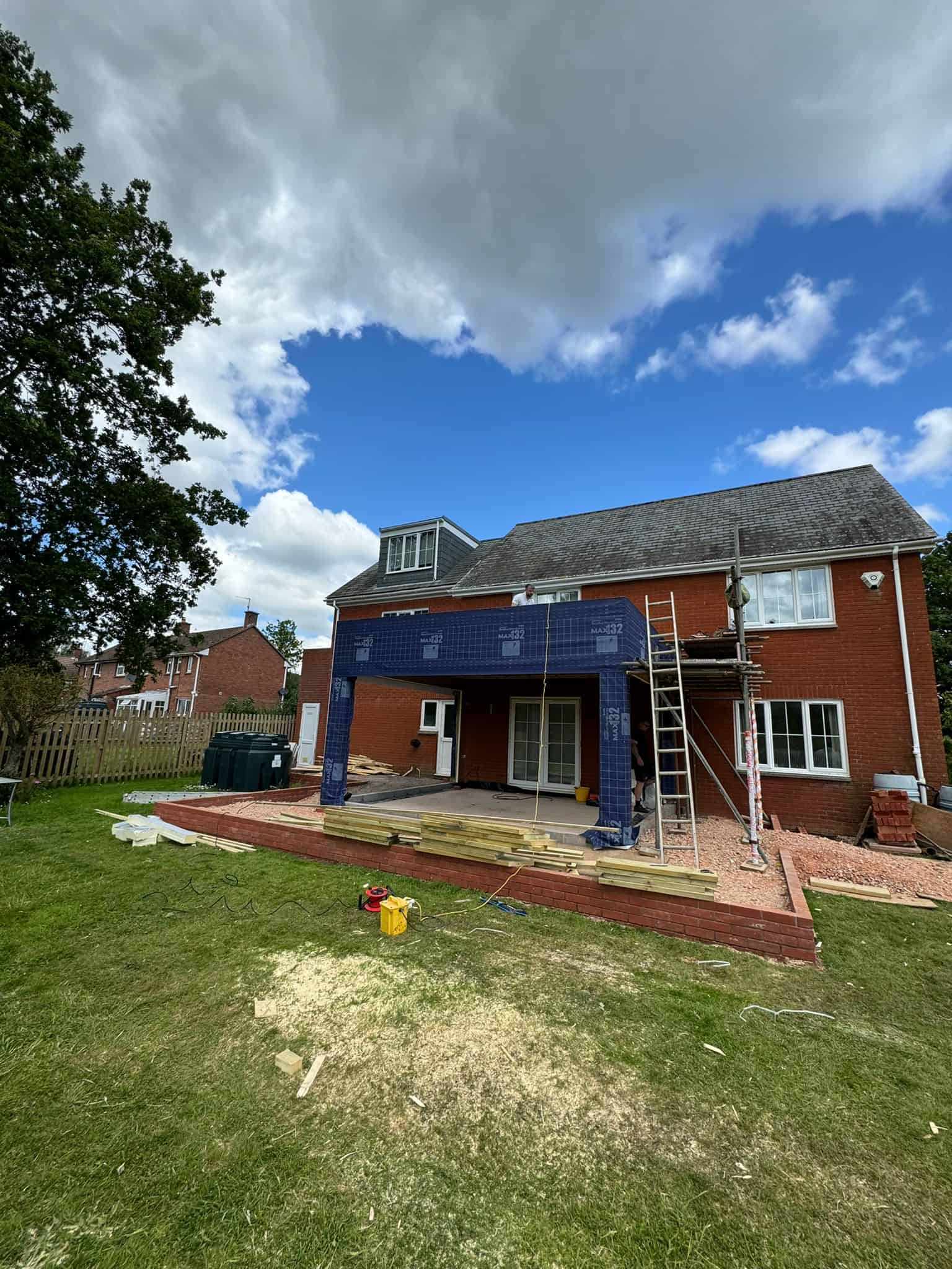 External house extension construction with scaffolding and brickwork by JB Carpentry & Construction.