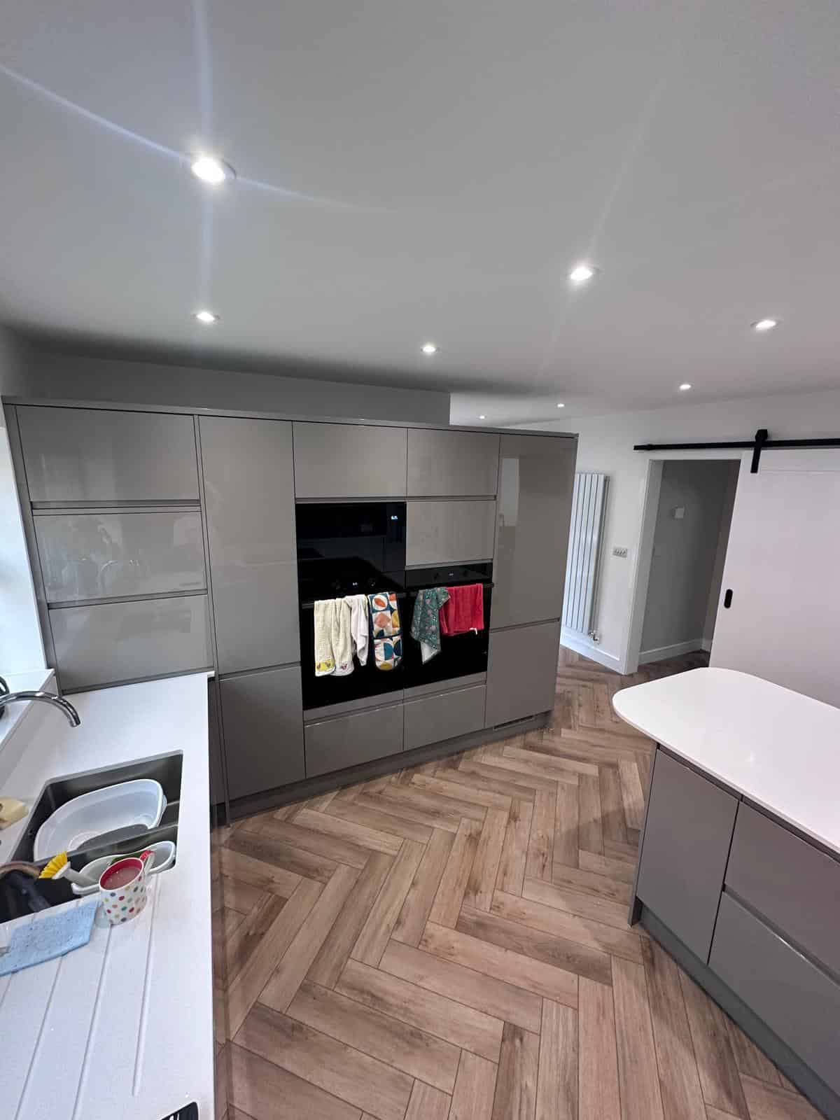 Modern grey kitchen units with seamless cabinetry and built-in appliances in a contemporary kitchen design.