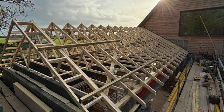 Wooden roof truss construction for a new building by JB Carpentry & Construction, expert in roofing and carpentry.